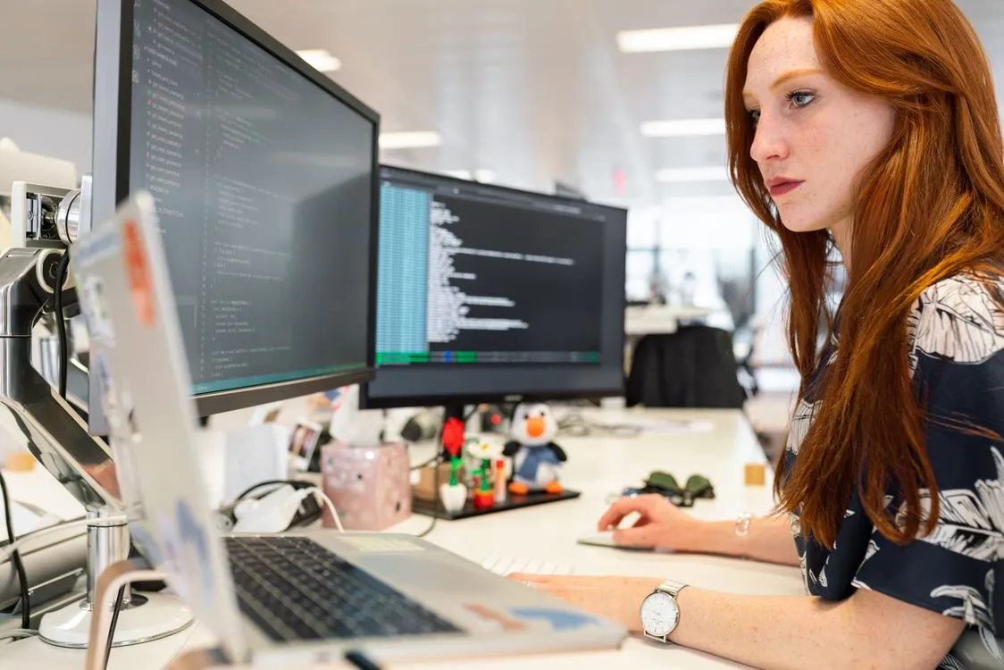 Developer reviewing code across desktop monitors